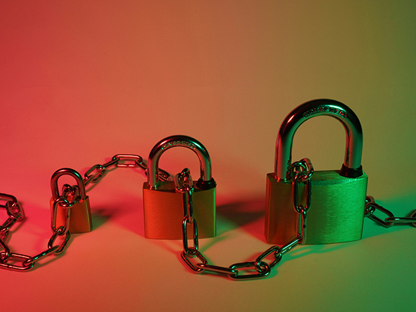 Three padlocks of different sizes linked by a chain