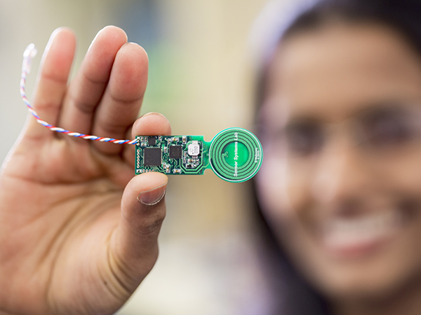 A person holds up a miniature sensor