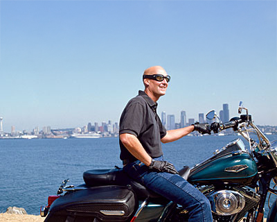 Brett Helsel seated on a motorcycle on the waterfront